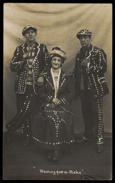 Download the full-sized image of A drag pearly queen and her two kings pose for a group portrait. Photographic postcard, 191-.