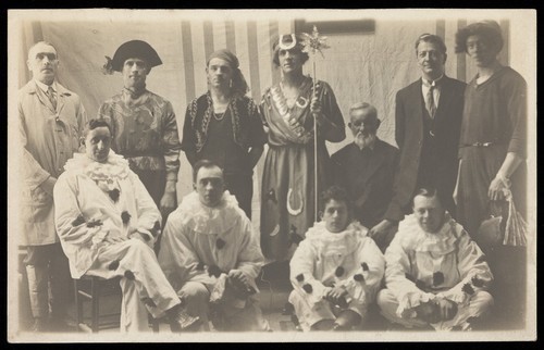 Download the full-sized image of Concert party performers, some in drag, pose for a group portrait. Photographic postcard, 191-.