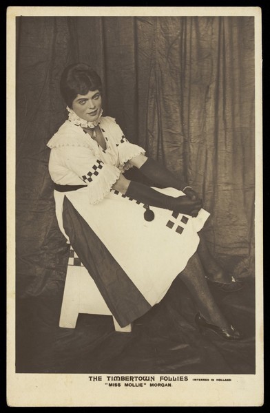 Download the full-sized image of A British prisoner of war in drag, performing for "The Timbertown Follies", at a prisoner of war camp in Groningen. Photographic postcard, 191-.