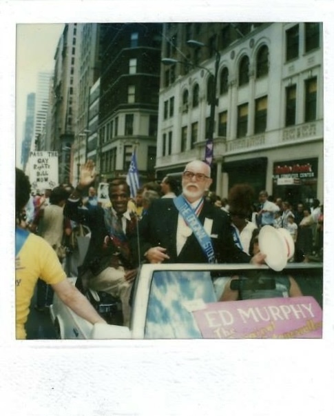 Download the full-sized image of A Photograph of Marsha P. Johnson Waving from a Car at the 1985 Christopher Street Liberation Day Parade with Ed Murphy