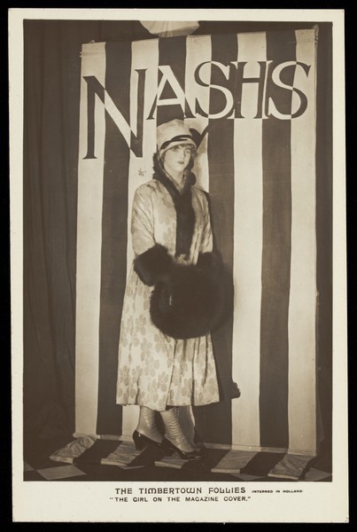Download the full-sized image of An soldier in drag modelling for "The Timbertown Follies" at a prisoner of war camp in Groningen. Photographic postcard, 191-.