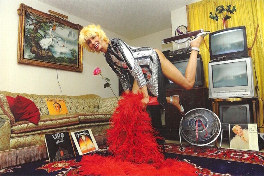 Download the full-sized image of A Photograph of Marlow Monique Dickson Posing in a Sequin Dress with a Red Feather Boa