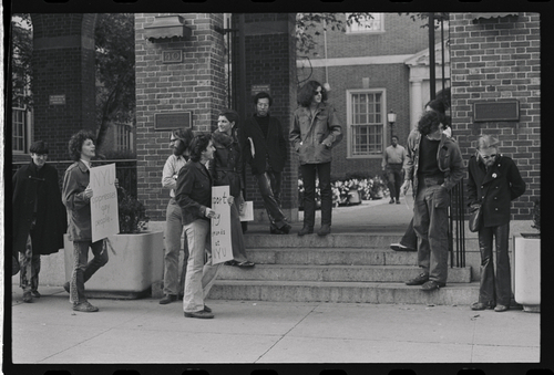 Download the full-sized image of A Photograph of Sylvia Rivera and Protesters with Signs, Standing Outside of a Building Entrance