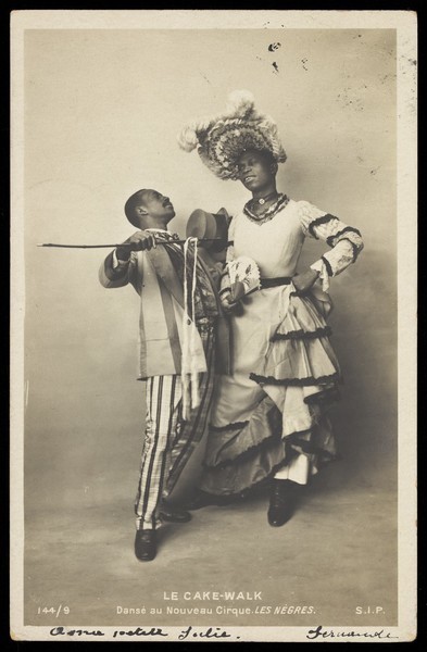 Download the full-sized image of Two black actors, one in drag, dancing the Cake-Walk in Paris. Photographic postcard, 1903.