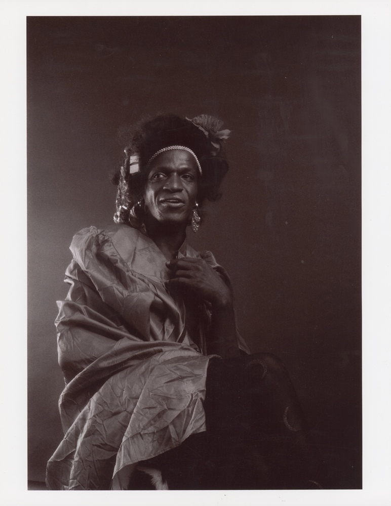 Download the full-sized image of A Portrait of Marsha P. Johnson Wearing a Silky Dress and Tights with Crescent Moons on Them