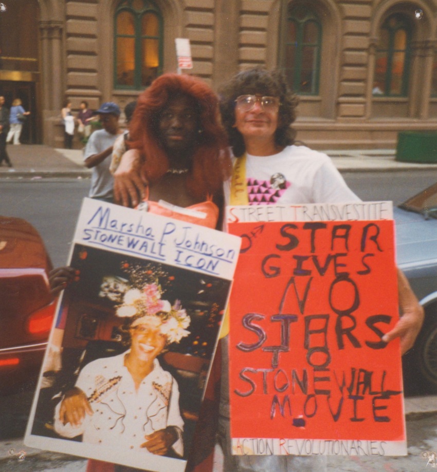 Download the full-sized image of A Photograph of Sylvia Rivera with Cocoa Rodriguez Holding Stonewall Posters Protesting the 1996 Stonewall Film Premiere