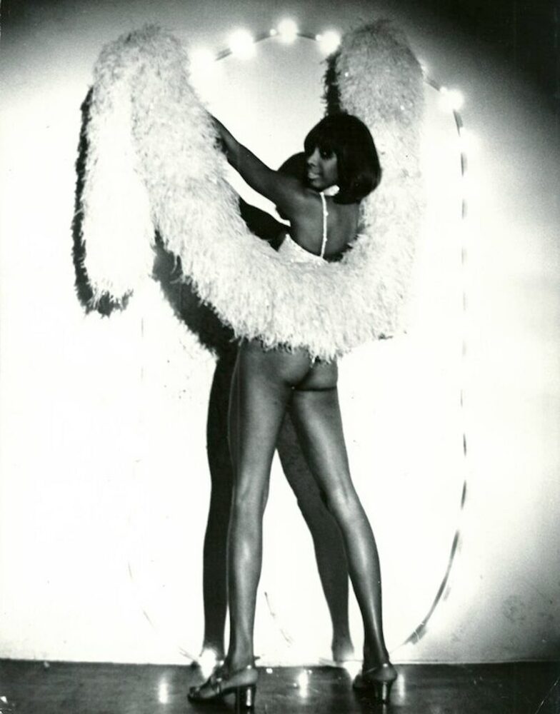 Download the full-sized image of A Photograph of Marlow Monique Dickson Posing with a White Feather Boa