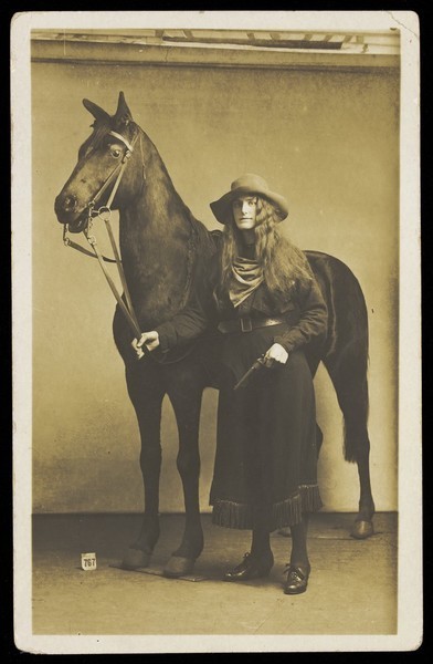 Download the full-sized image of A man dressed in drag as a cowgirl. Photographic postcard, ca. 1915-1920.