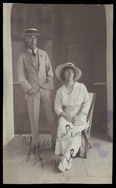 Download the full-sized image of Two men, one in drag, posing in front of a doorway. Photograph, 191-.