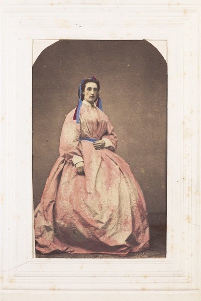 Download the full-sized image of A man in drag poses wearing a large pink dress. Photograph, 189-.