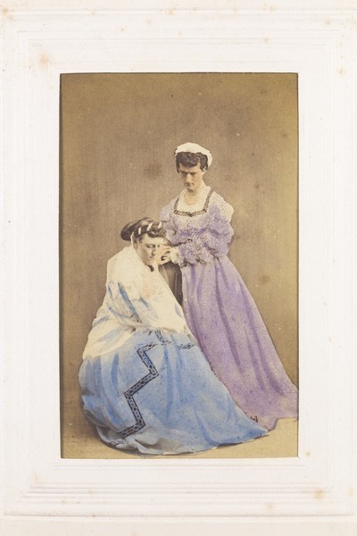 Download the full-sized image of Two men in drag posing in the act of dressing. Photograph, 189-.