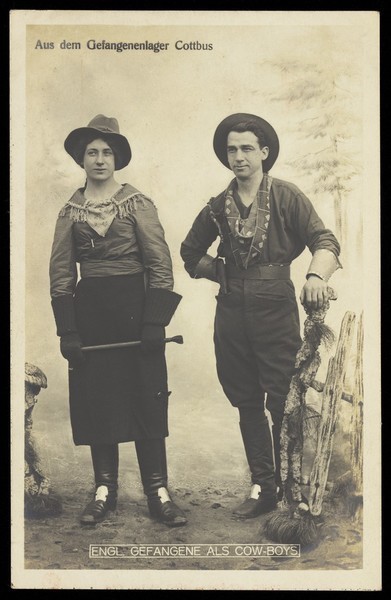Download the full-sized image of British prisoners of war in cowboy and cowgirl costumes posing at a prisoner of war camp in Cottbus. Photographic postcard by P. Tharan, 191-.