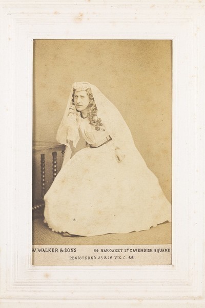Download the full-sized image of A man in drag dressed as a bride, looking glum. Photograph, 189-.