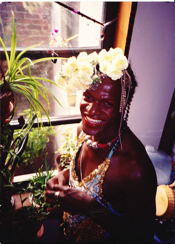 Download the full-sized image of A Photograph of Marsha P. Johnson Standing in a Window with a White Flower Headpiece