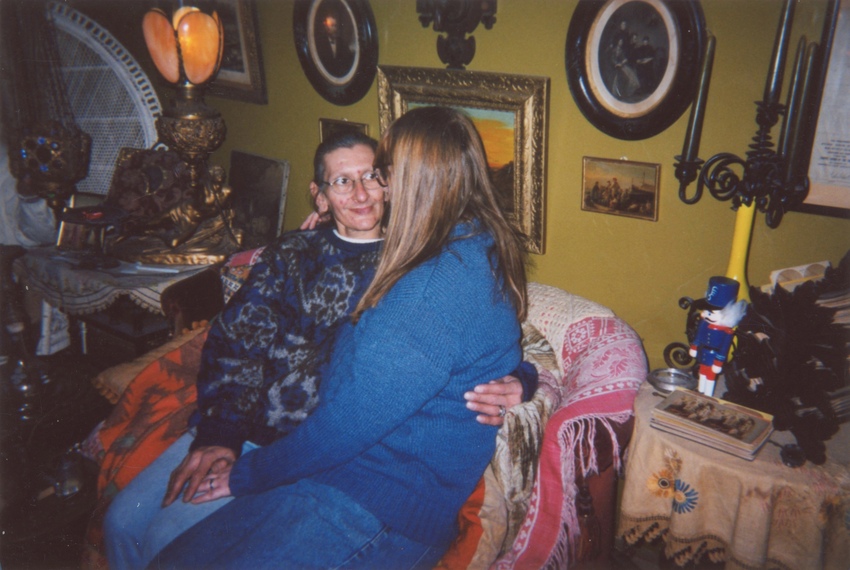 Download the full-sized image of A Photograph of Sylvia Rivera With Her Arm Around Her Partner Julia Murray, Sitting on a Couch