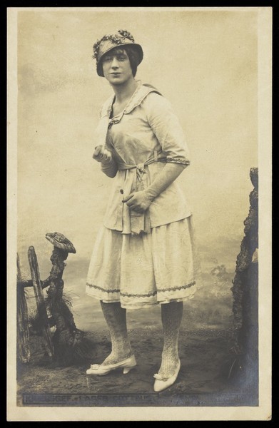 Download the full-sized image of An actor, in drag, performing English theatre at a prisoner of war camp in Cottbus. Photographic postcard, 191-.