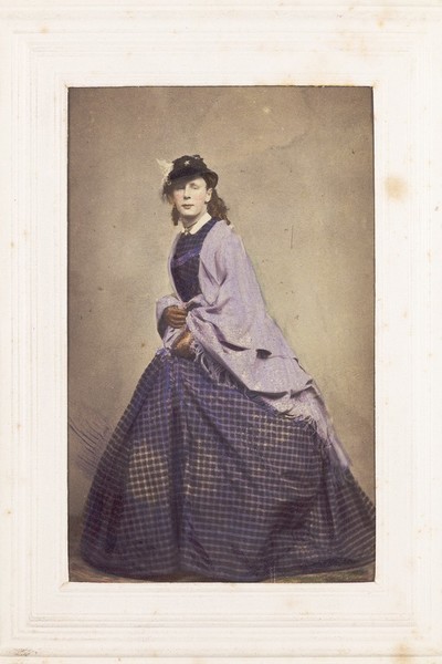 Download the full-sized image of A man in drag poses wearing mauve attire. Photograph, 189-.