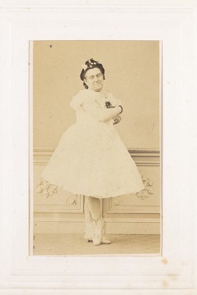Download the full-sized image of A man in drag poses with his arms crossed, wearing a ballerina costume. Photograph, 189-.