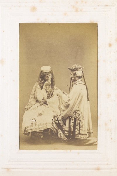 Download the full-sized image of Two men in drag (?) sitting opposite each other. Photograph, 189-.